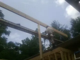 Carpenter setting a ridge beam over a new addition frame — Ice Dam Removal by Roofing Brothers in Coram